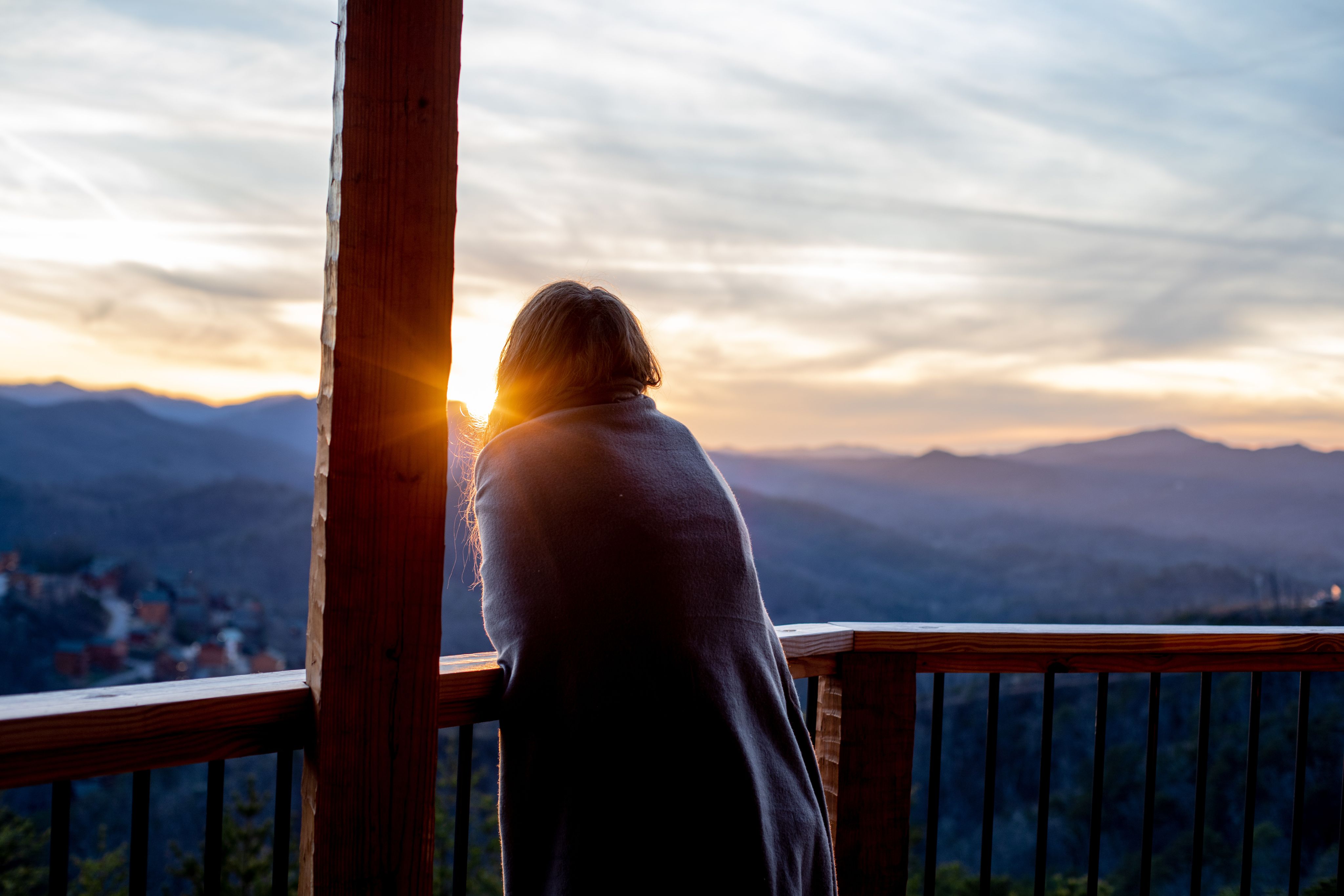 Young woman looking from balcony of Gatlinburg cabin