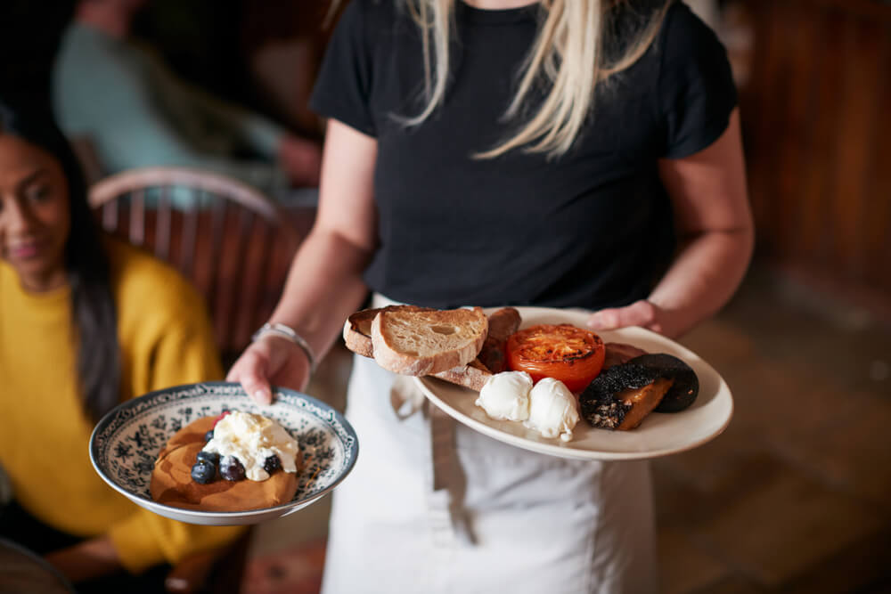 A woman carrying plates at a breakfast restaurant in Gatlinburg.